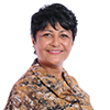 A woman with short dark hair and a patterned shirt smiles at the camera.