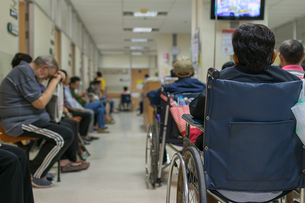 An NHS hospital waiting room with patients waiting to be seen