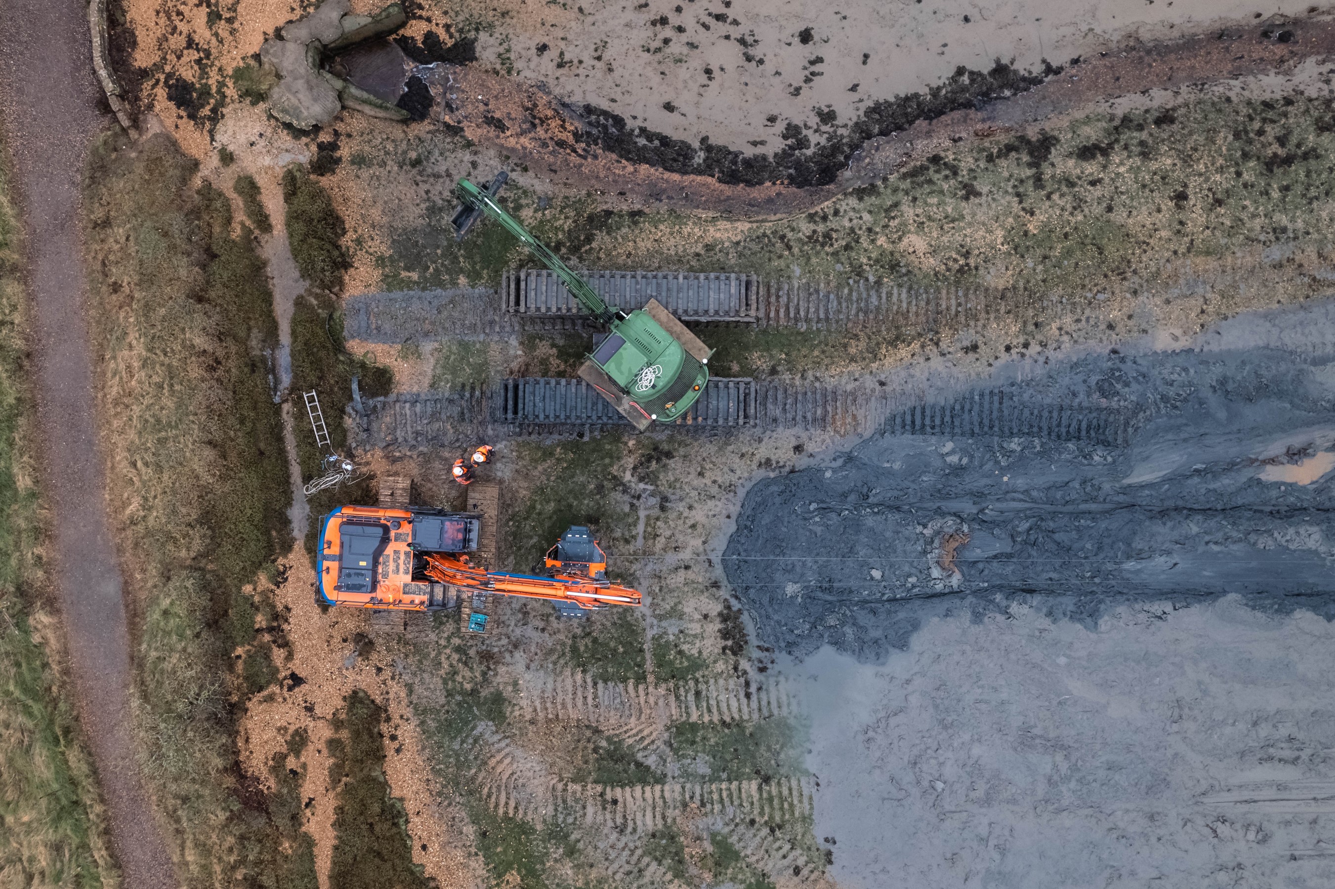 An aerial view of sediment being spread to restore the saltmarsh by diggers