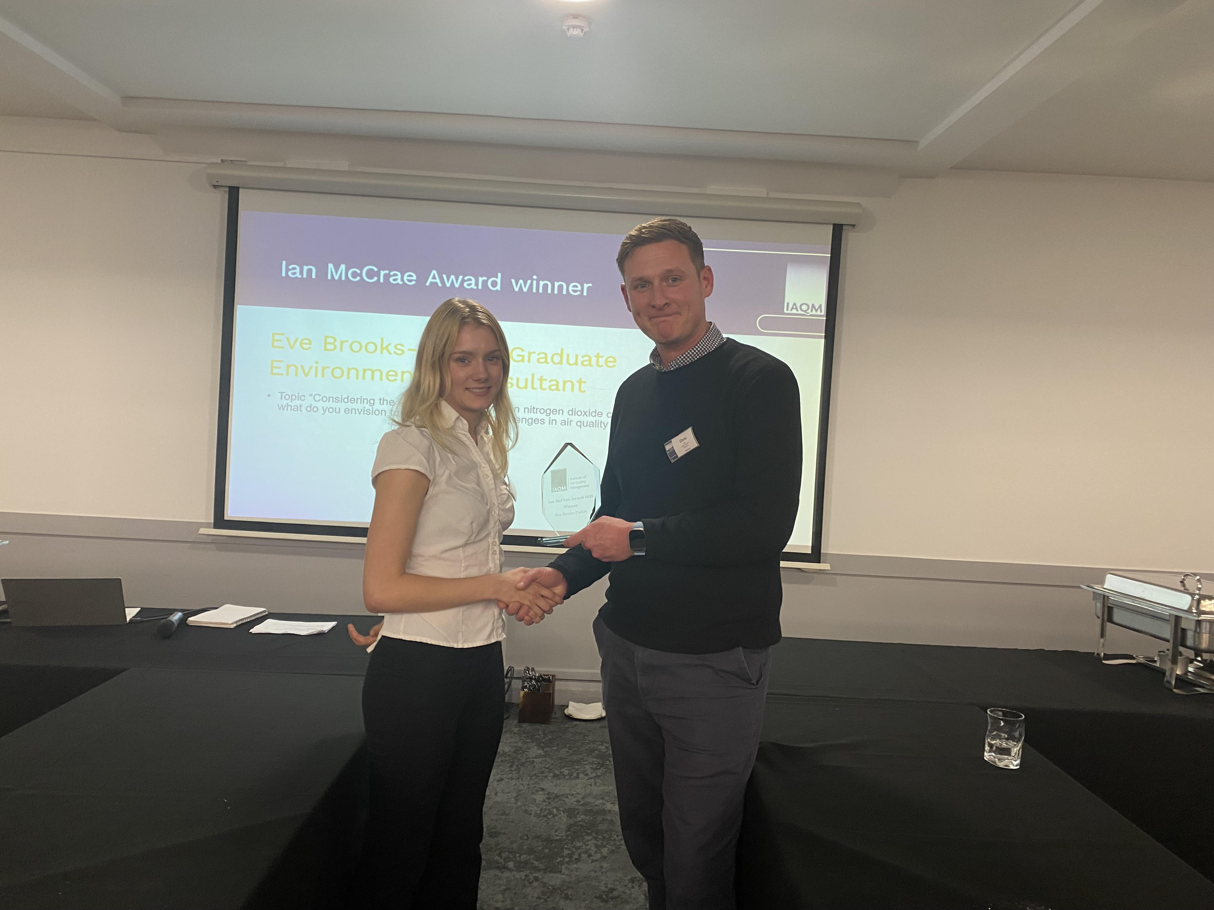 IAQM Chair Chris Rush hands Eve Brooks-Parkin the 2025 Ian McCrae Award