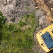 Yellow digger clearing land from above