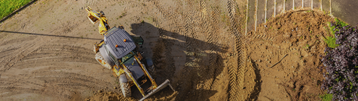 photo of yellow digger over brown earth