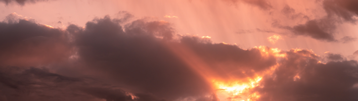 Photograph of clouds with orange light breaking through