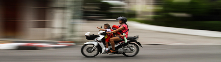 Photo of a woman and her child on a speeding motorbike. 