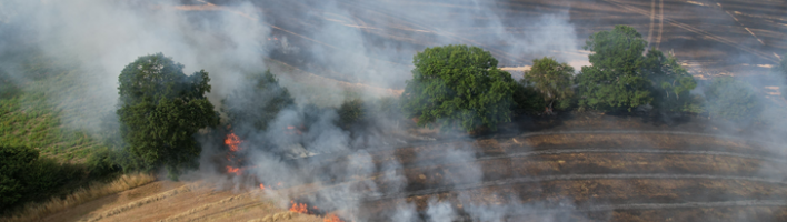 farmland burning with smoke rising after extreme heat