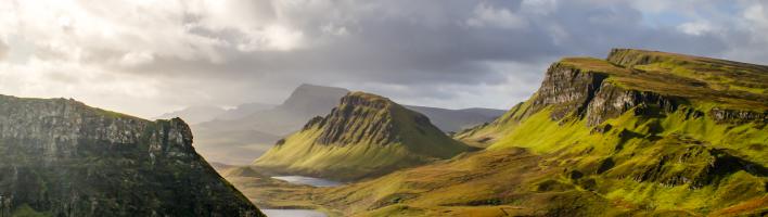 A dramatic landscape in the UK, with rolling green mountain scenery and a cloudy but blue sky. Copyright Dominic Meijers, Adobe Stock