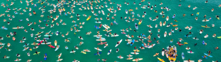 Group of surfers in the ocean pictured from above
