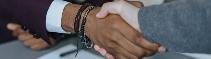 two people shaking hands over a table