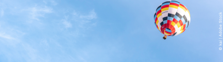 Multi-coloured hot air balloon floating mid-air