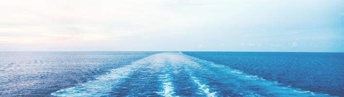 View of blue sea with water ripples from a moving boat not shown.