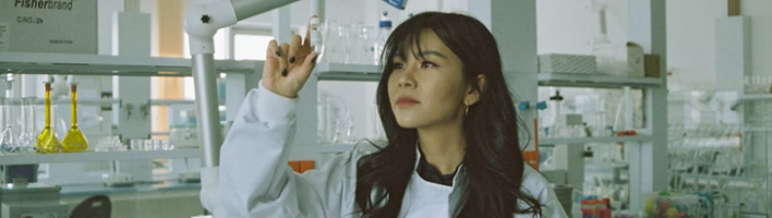 Female scientist looking at beaker