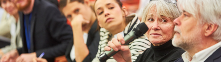 Audience speaking up at a microphone