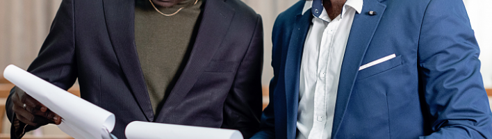 Two people in suits looking at charts