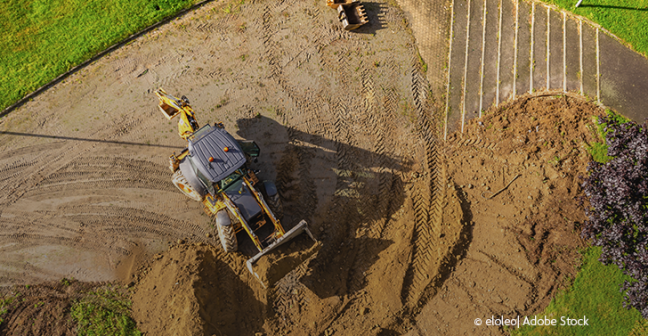 photo of yellow digger over brown earth