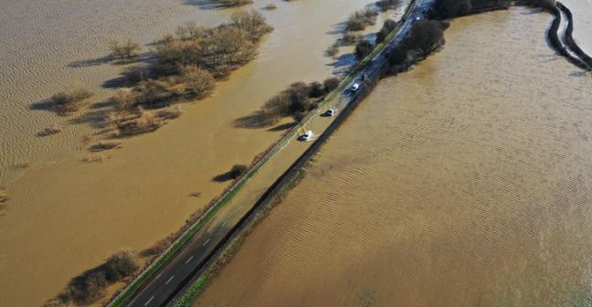 Photograph of flooded road and flooded fields in the UK taken from above 