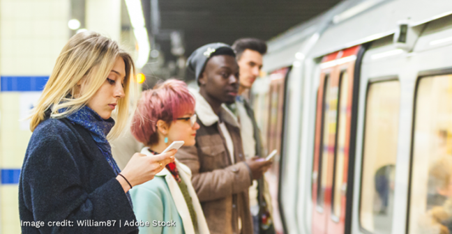 People checking social media near a train