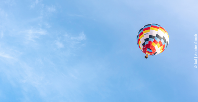 Multi-coloured hot air balloon floating mid-air