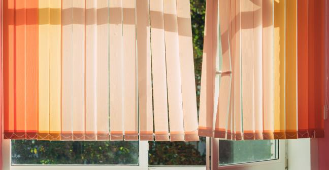 Blinds swaying in front of an open window.