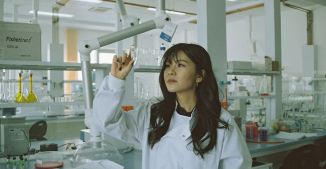 Female scientist looking at beaker