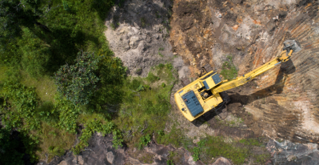 Yellow digger clearing land from above