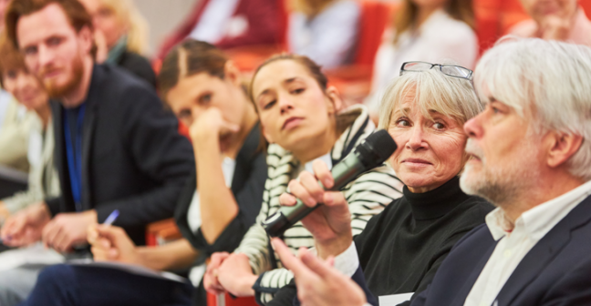 Audience speaking up at a microphone