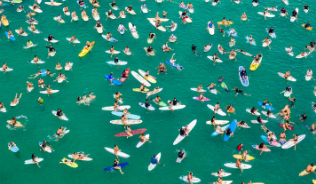 Group of surfers in the ocean pictured from above