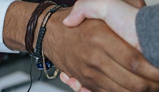 two people shaking hands over a table