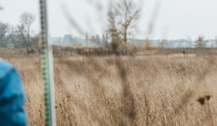 Environmental professionals working in a pair in a field with technical instruments