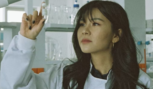 Female scientist looking at beaker