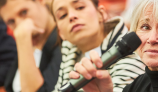 Audience speaking up at a microphone