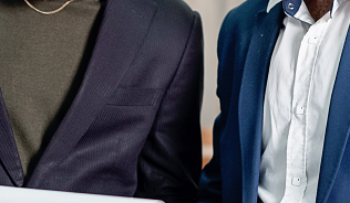 Two people in suits looking at charts