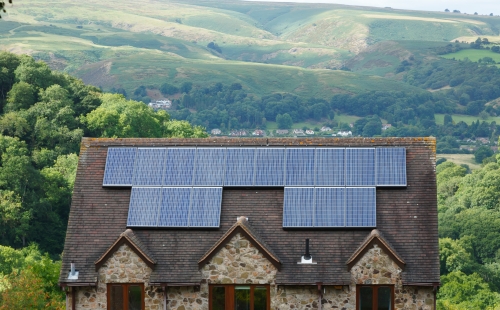 A house retrofitted with solar panels in the middle of a moorland