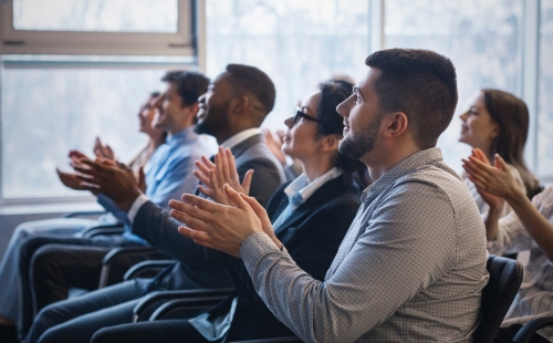 Professionals applauding at a conference