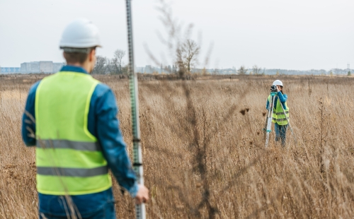 Surveyors measuring land with digital levels and ruler