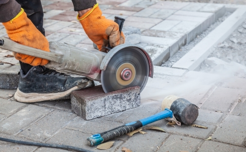 Noisy construction worker cutting stone