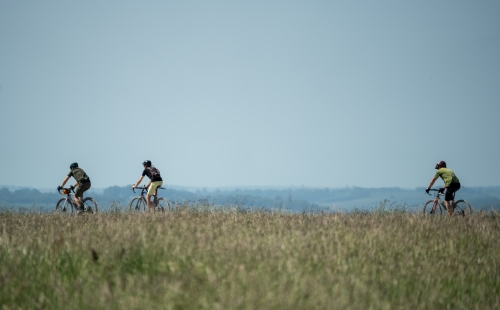 Group of people cycling across a field
