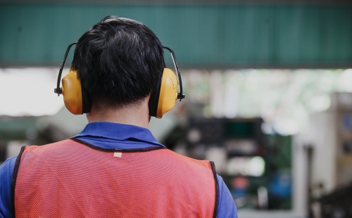 A man wearing soundproof headphones at work 