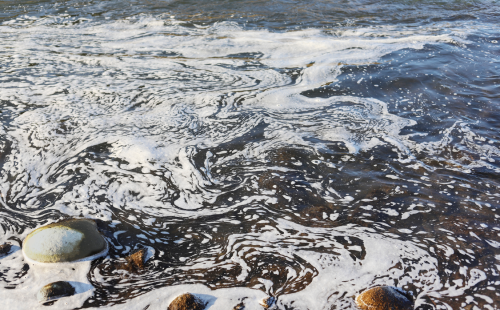 Foam on the surface of a river caused by chemical pollution.