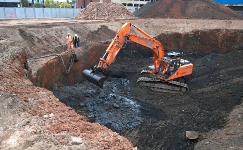 Excavator at urban construction site