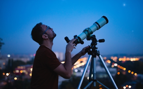 Man searching the skies with a telescope, looking for something