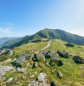Hiker walking along a trail hign in the hills