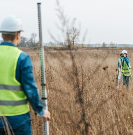 Surveyors measuring land with digital levels and ruler