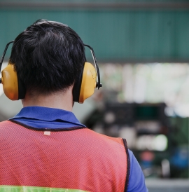 A man wearing soundproof headphones at work 