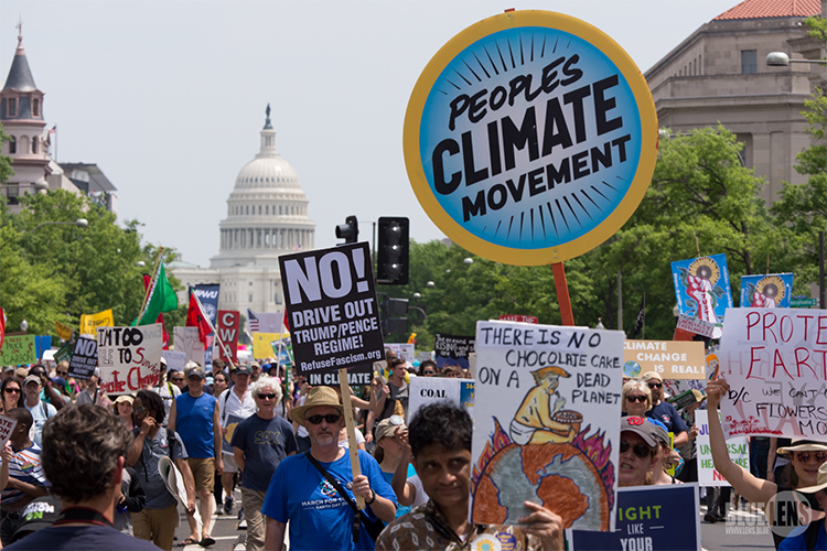 A 2017 climate protest in Washington DC with signs in front of the Capitol building